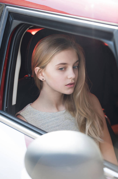 Kaunis tyttö, jolla on mietteliäs kasvot, katselee auton ikkunasta
 - Valokuva, kuva
