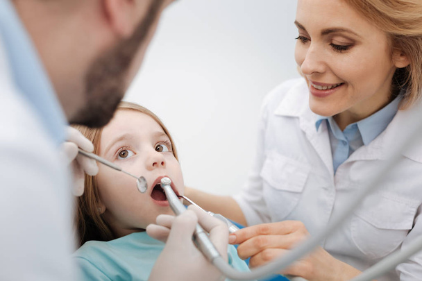 Mooie uitstekende tandartsen het verzorgen van hun patiënt - Foto, afbeelding