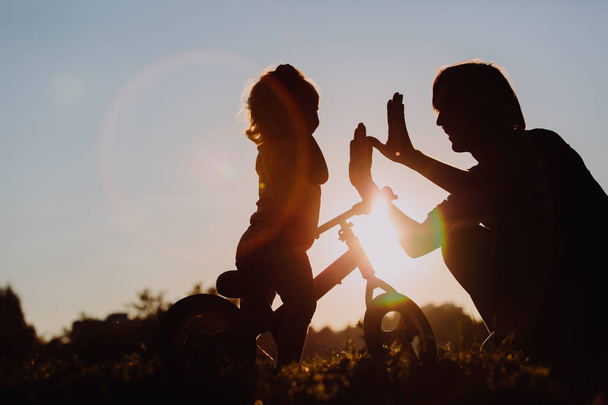 padre e figlia si divertono a pedalare al tramonto
 - Foto, immagini