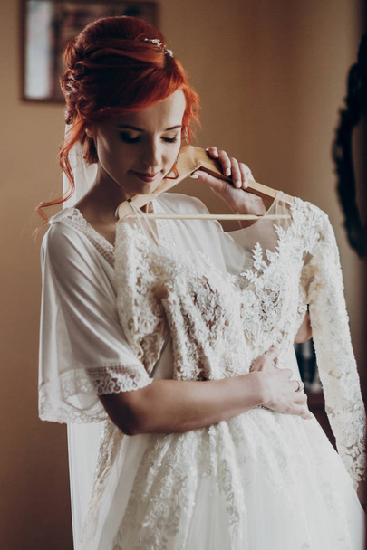 Braut hält ihr Hochzeitskleid - Foto, Bild