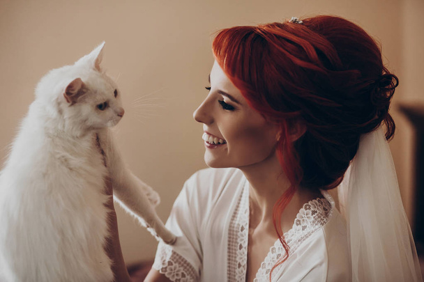 noiva brincando com gato branco
 - Foto, Imagem