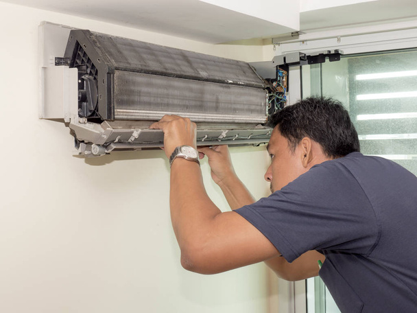 Homme électricien célibataire nettoyer, réparer et entretenir la climatisation
  - Photo, image