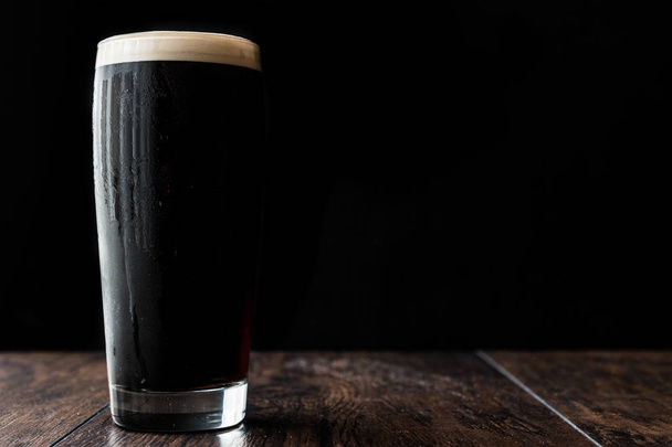Dark beer on wooden surface. copy space. - Photo, image
