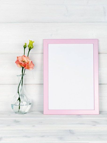 Flowers in vase and a photo frame on a wooden background. - Photo, Image