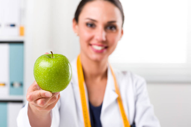 緑のリンゴを与える女性栄養士 - 写真・画像
