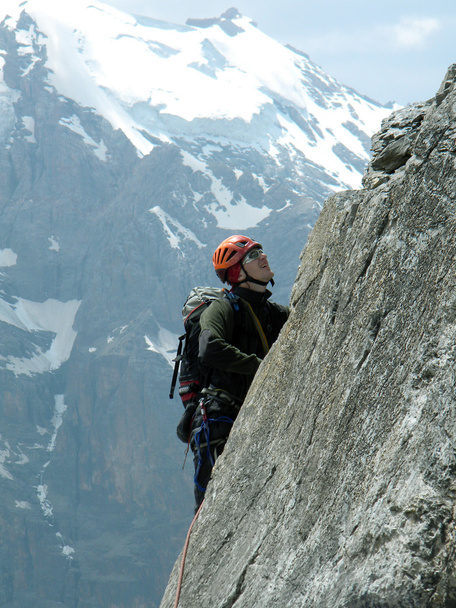Young man climbing on a limestone wall with wide valley on the background - Photo, Image