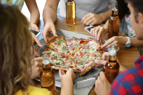Young friends with pizza and beer in cafe - Φωτογραφία, εικόνα