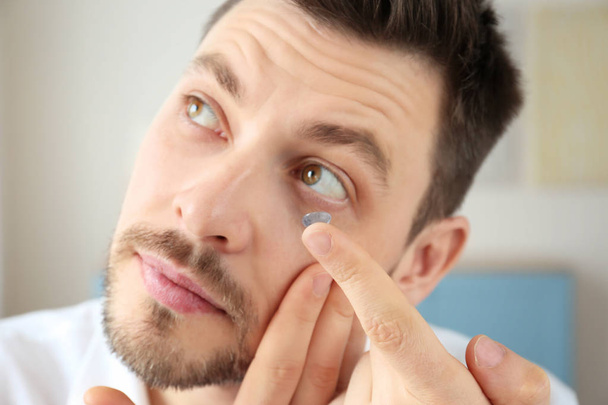 Young man putting contact lenses   - Photo, Image