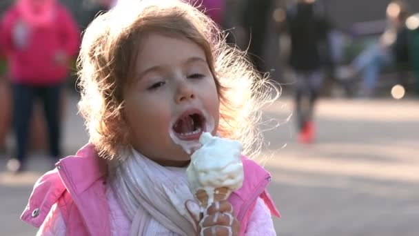Cute toddler girl eating ice cream in the City Park. Slow motion. - Séquence, vidéo