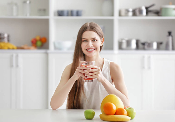 Woman tasting juice at kitchen - 写真・画像