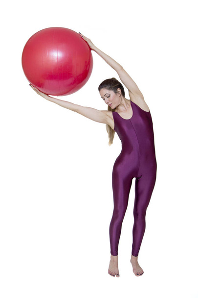 Frau trainiert mit rotem Pilates-Ball - Foto, Bild