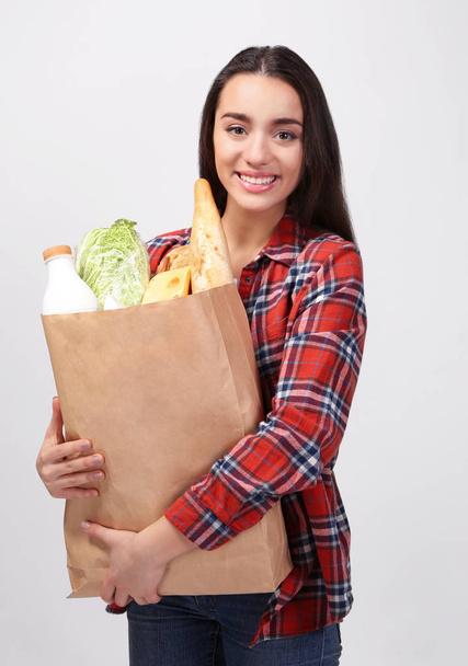 женщина с бумажным пакетом продукции
 - Фото, изображение