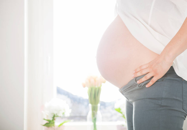 Pregnant woman at home close up of belly - Φωτογραφία, εικόνα