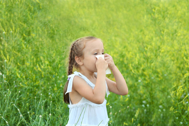 Seasonal allergy. Little girl with tissue outdoor - Фото, зображення