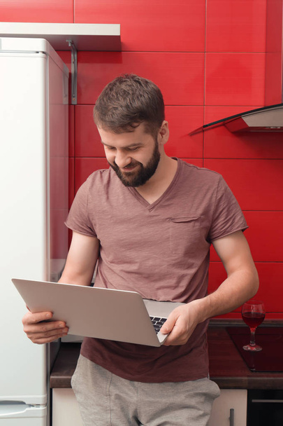Man using laptop in kitchen - Fotoğraf, Görsel