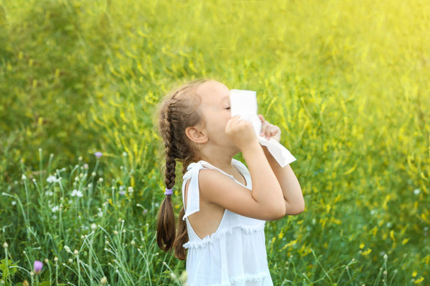 Seasonal allergy. Little girl with tissue outdoor - Фото, зображення