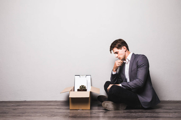 Sad fired businessman sitting at floor after being dismissed at work in office - Photo, Image