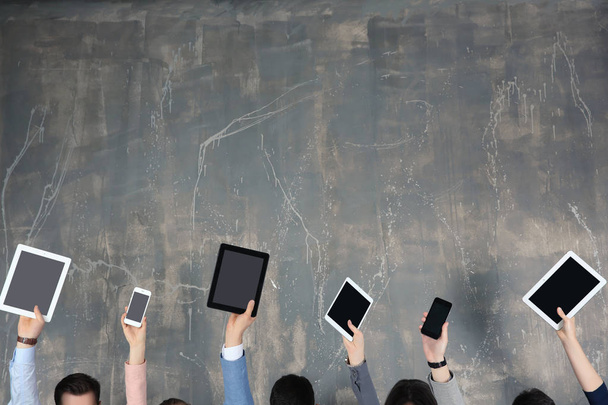 People raising hands with digital devices - Photo, image