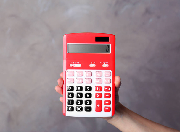 Hand holding red calculator - 写真・画像