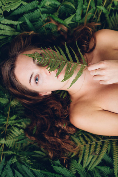 Red-haired girl with fern - Foto, imagen