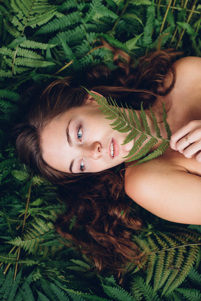 Red-haired girl with fern - Foto, afbeelding