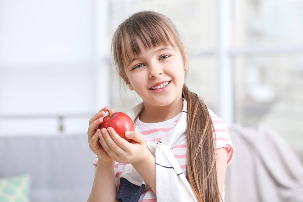 Happy schoolgirl sitting with apple   - Fotó, kép