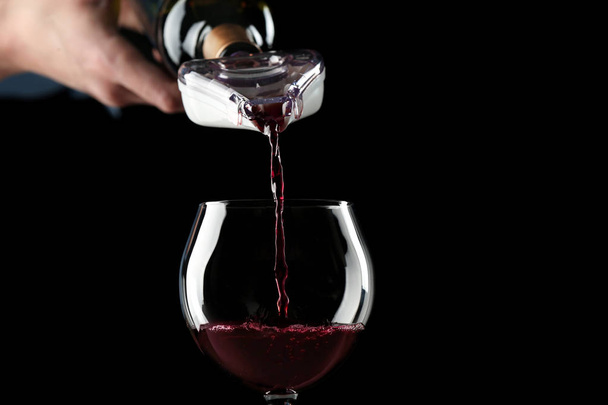 χύνοντας κόκκινο κρασί στο ποτήρι  - Φωτογραφία, εικόνα