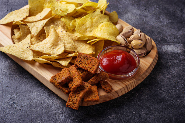 Surtido de bocadillos. Chips, pistachos, nachos y cacahuetes
 - Foto, Imagen