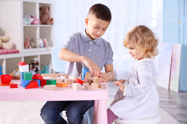 Cute little sister and brother playing with toy blocks at home - Foto, imagen