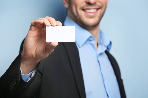 Young man with business card on color background, closeup - Foto, Imagem