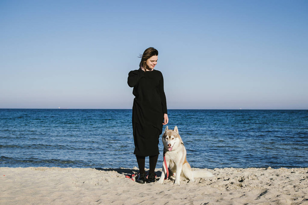 Woman on sea beach with siberian husky dog - Foto, Imagem