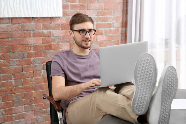 Handsome young man with laptop  - Фото, изображение
