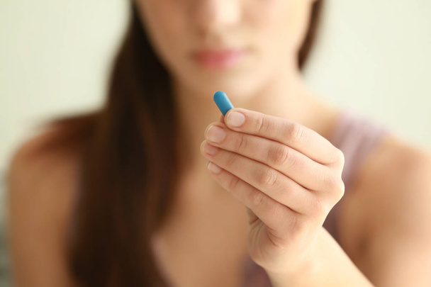 Woman holding pill - Foto, afbeelding