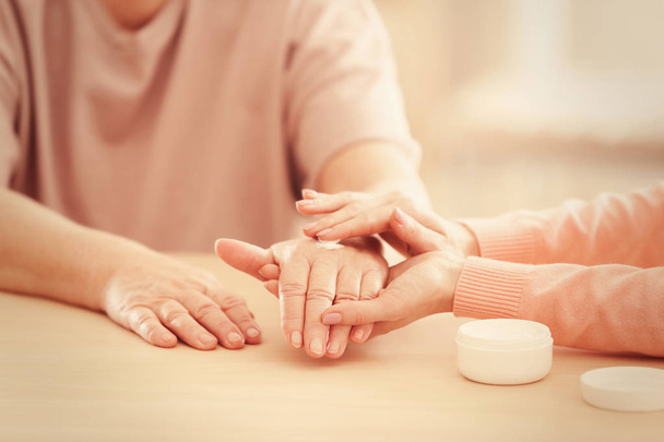 applying cream on hands of elderly patient - Fotoğraf, Görsel