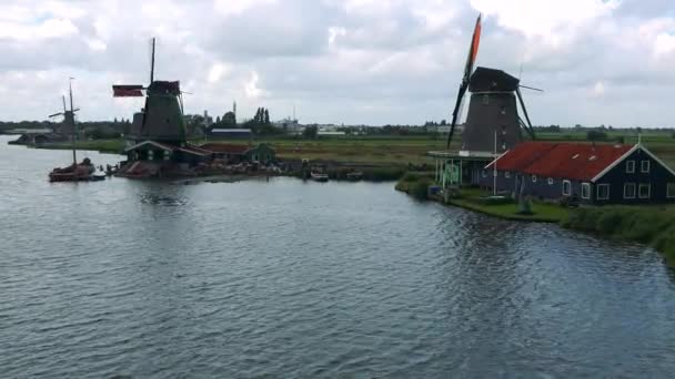 Moinhos de vento por um rio em uma área rural
 - Filmagem, Vídeo