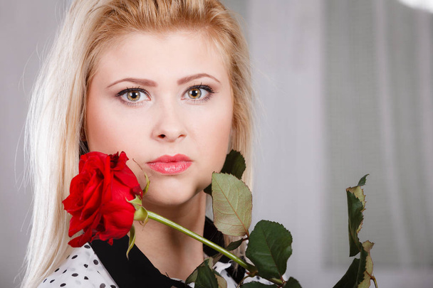 woman holding red rose near face looking melancholic - Photo, Image