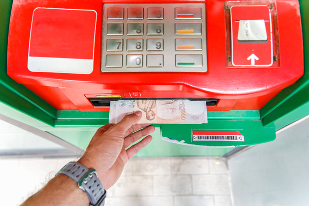 Recoger billetes de 1000 baht tailandeses en el cajero automático
. - Foto, imagen