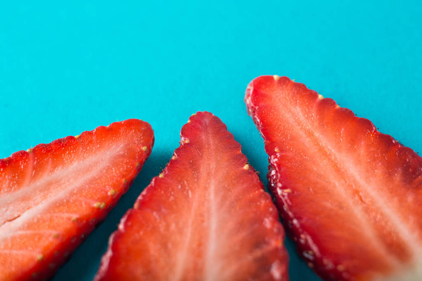 Strawberry slice blue background - Zdjęcie, obraz