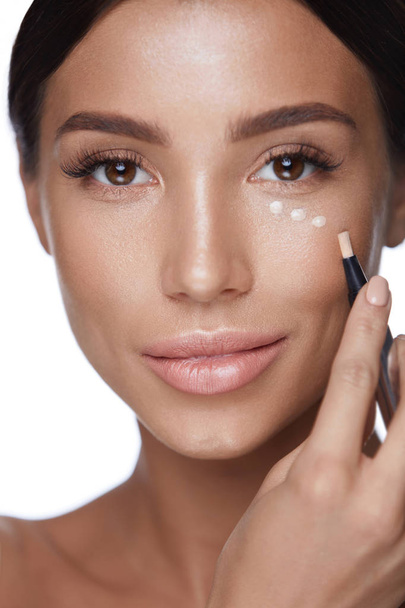 Cosmetics. Beautiful Woman Applying Concealer On Skin Under Eyes - Φωτογραφία, εικόνα