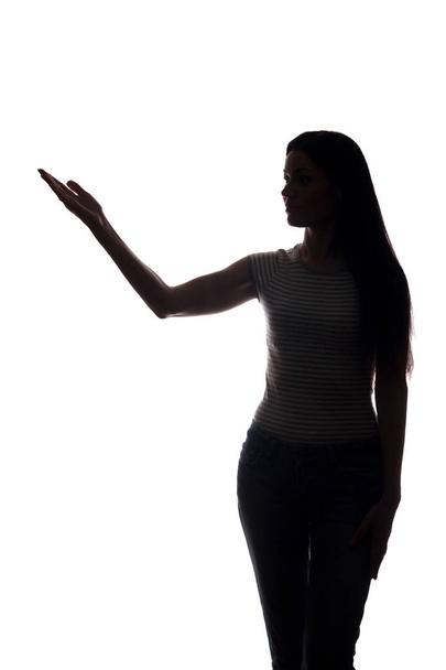Mujer joven en traje muestra su dedo índice, la mano hacia adelante
 - Foto, Imagen