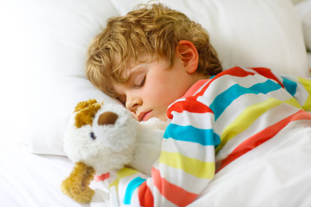 little blond kid boy in colorful nightwear clothes sleeping - Foto, Bild