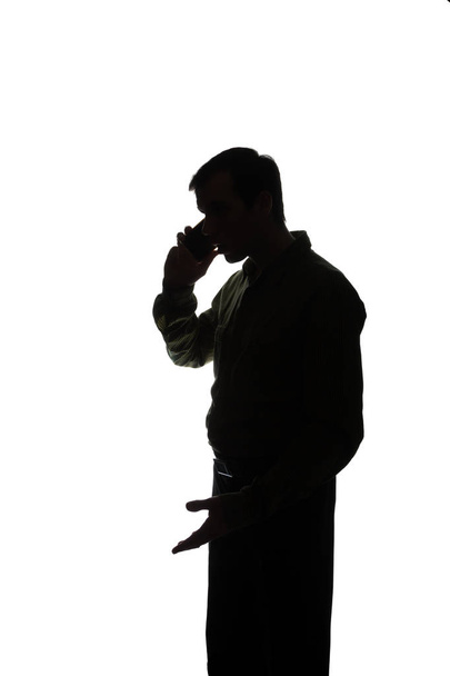 Portrait of a young man with a smartphone, tablet in hand, talk - silhouette - Photo, Image