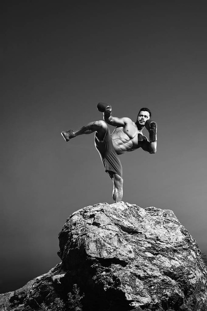 Monochrome shots of a fierce male boxer training outdoors - Foto, Imagen