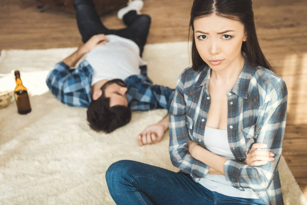 woman sitting on floor near drunk boyfriend - Foto, Imagem