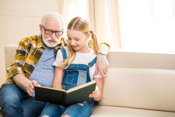 Grandfather with girl reading book - Фото, зображення