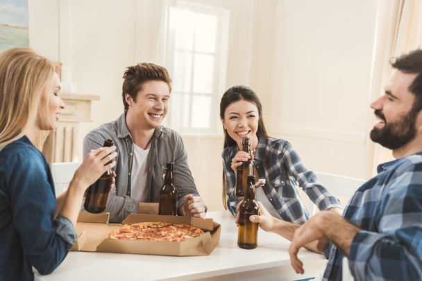 couples drinking beer and eating pizza - Фото, зображення