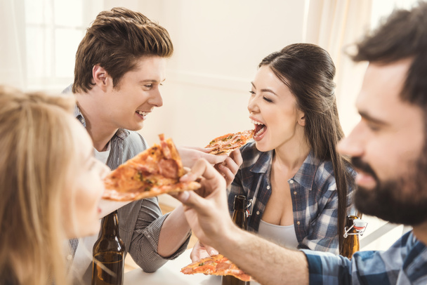 couples drinking beer and eating pizza - Photo, Image