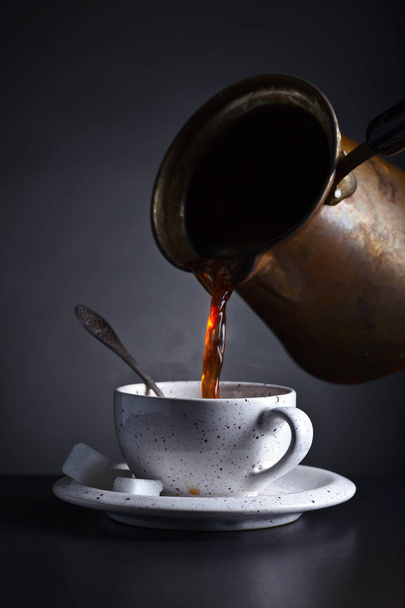 Verse warme koffie wordt gegoten in de beker . - Foto, afbeelding
