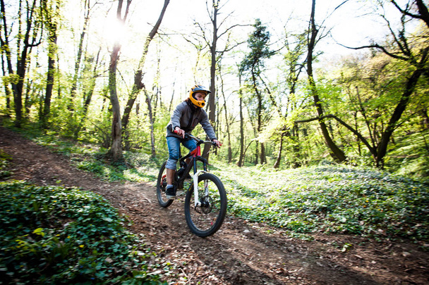 man ride mountain bike through forest - Фото, зображення