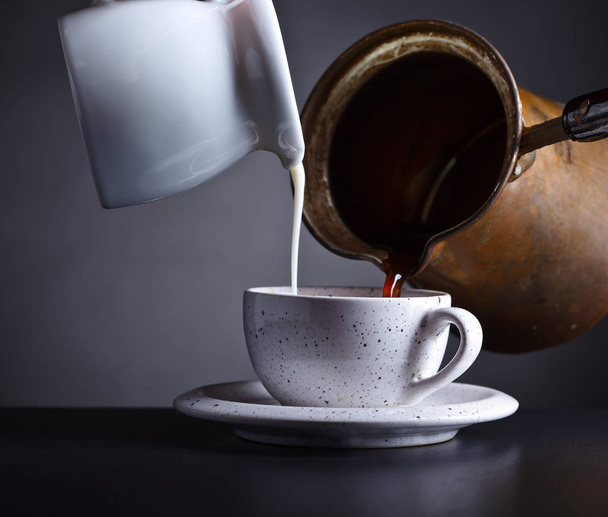  Świeżej gorącej kawy i mleka przelewa się do szklanki  - Zdjęcie, obraz